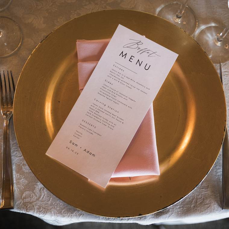 A place setting with a printed menu on a gold charger