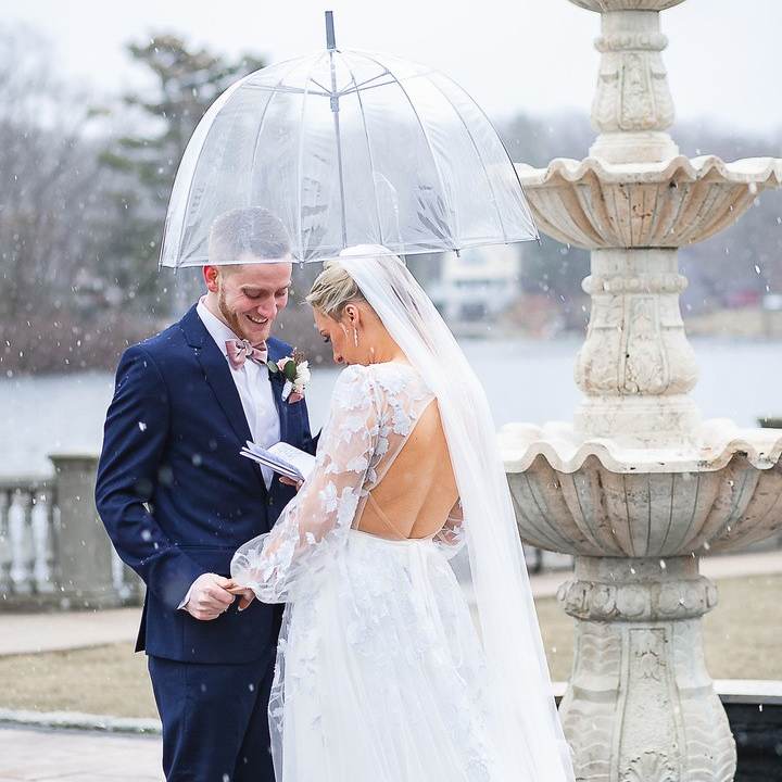 A couple exchanging vows beside a snow-covered fountain