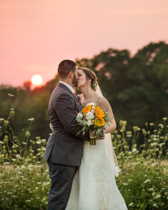 A couple at sunset on the hillside at Harrington Farm
