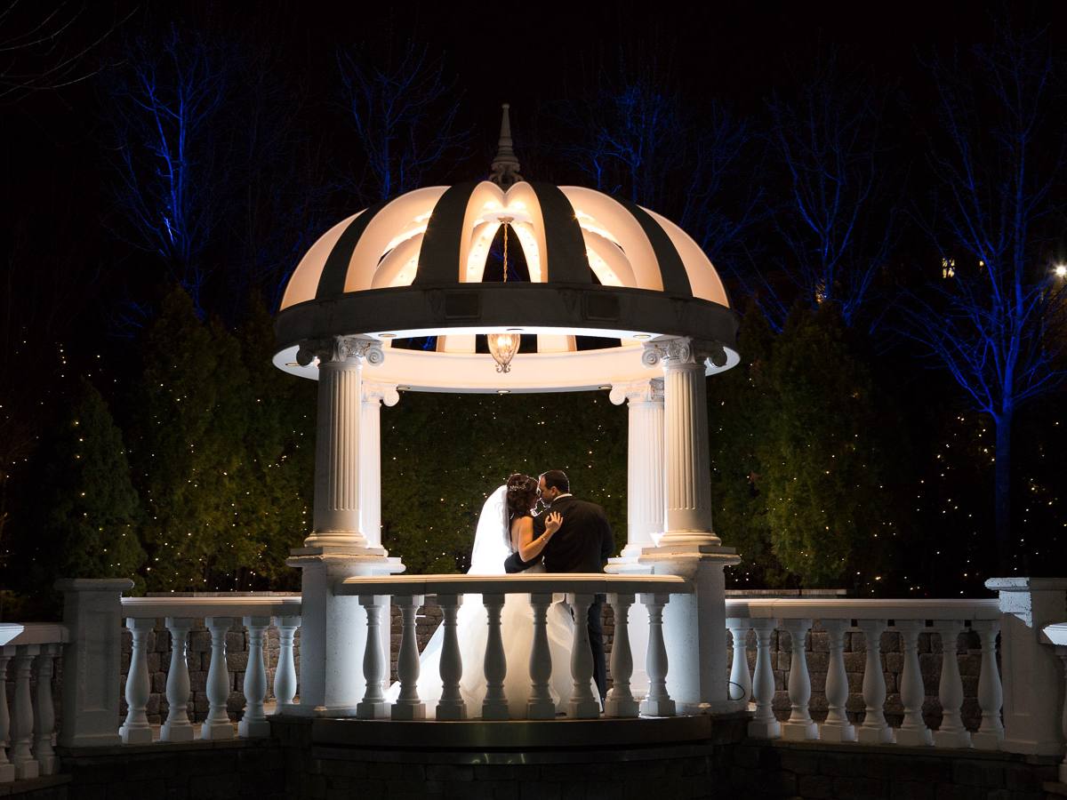 The illuminated gazebo and gardens at Westmount Country Club at dusk, with the valley beyond